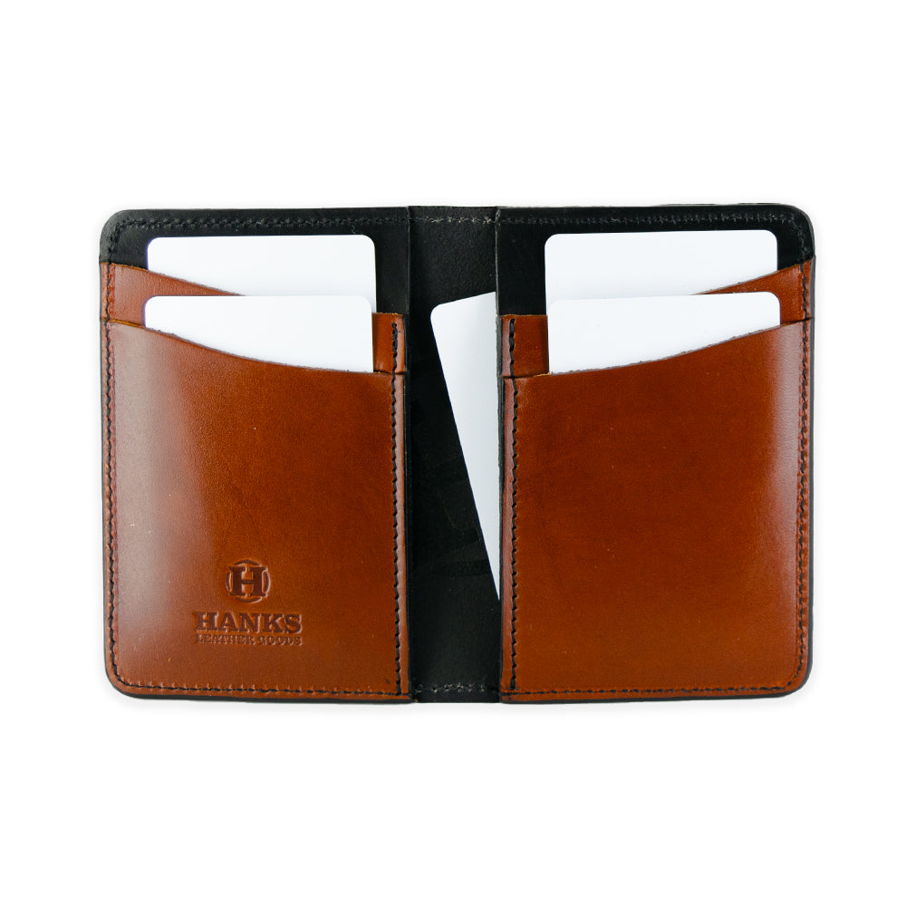 Open brown leather Superior Front Pocket Bifold wallet with multiple card slots, holding white cards. "Hanks Belts" is embossed on the lower left, showcasing its craftsmanship as a handcrafted wallet from premium harness leather.