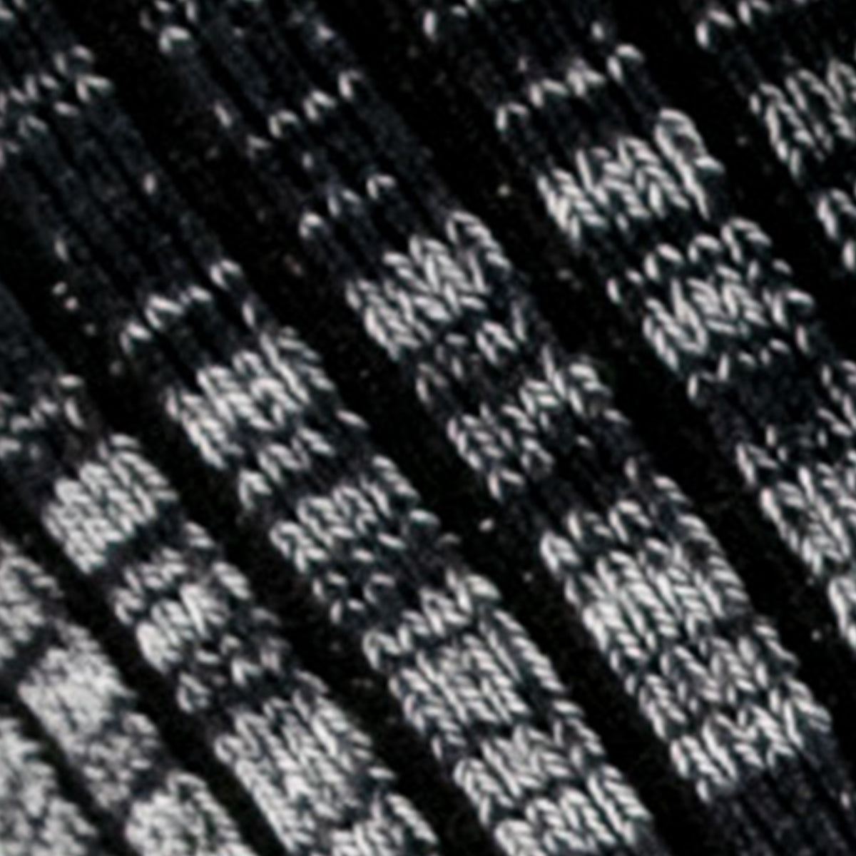 Close-up of the Upland Socks by Hank Belts shows black and white knitted fabric with a textured striped pattern. Thick yarn and visible stitches evoke classic American-made work socks.