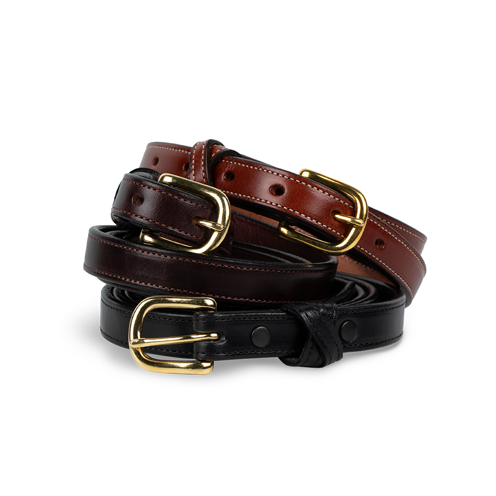 Two Hanks Belts "The Dixie" women's belts—one brown, one black with gold buckles—are coiled together on a white background, highlighting fine American craftsmanship and premium English Bridle leather.