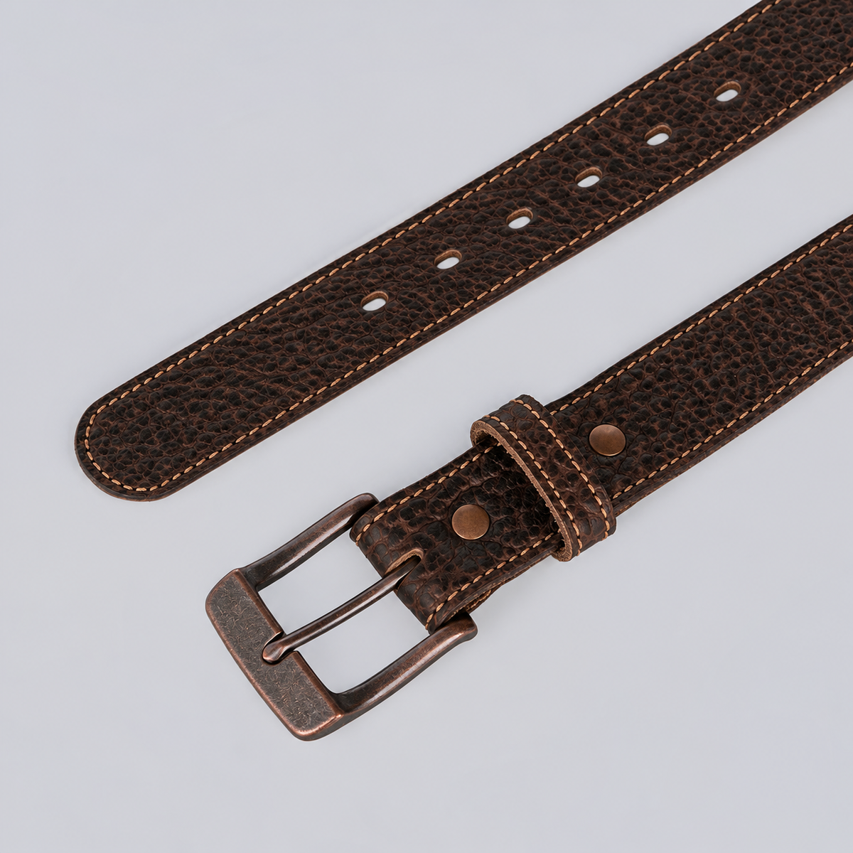 The Yellowstone - 1.25″ brown textured leather belt with contrast stitching and a dark metal buckle.