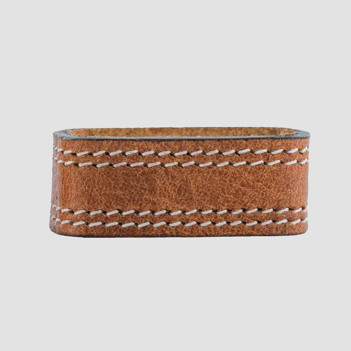The Hanks Belts 1.5" Double Stitched #4 Keeper, made of harness leather with visible white stitching, recalls the craftsmanship of Old World Harness Belts and is shown against a plain light gray background.