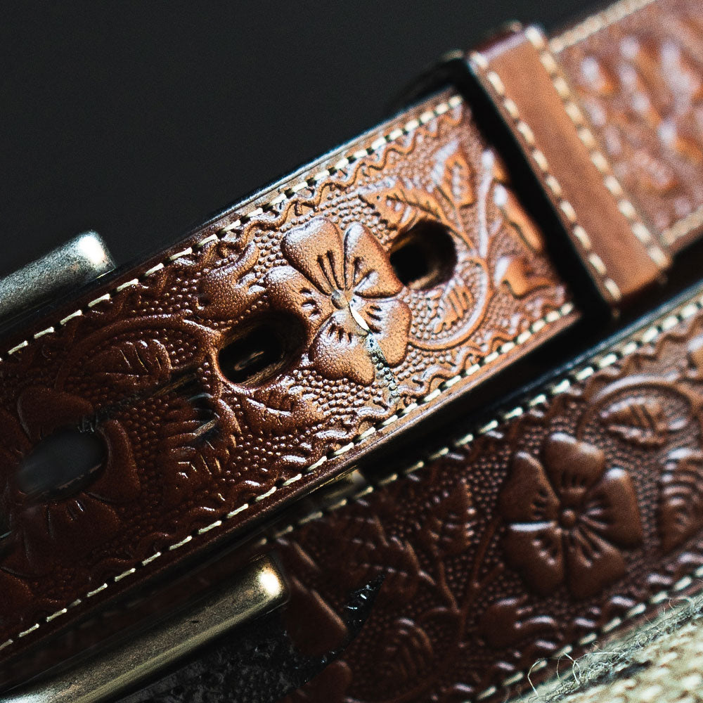 Close-up of The Floral Embossed by Hanks Belts, a USA-made full-grain leather belt featuring detailed floral embossing and visible stitching to showcase its intricate craftsmanship.