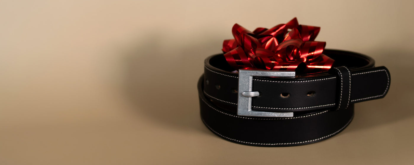 Black belt with a red bow on a beige background