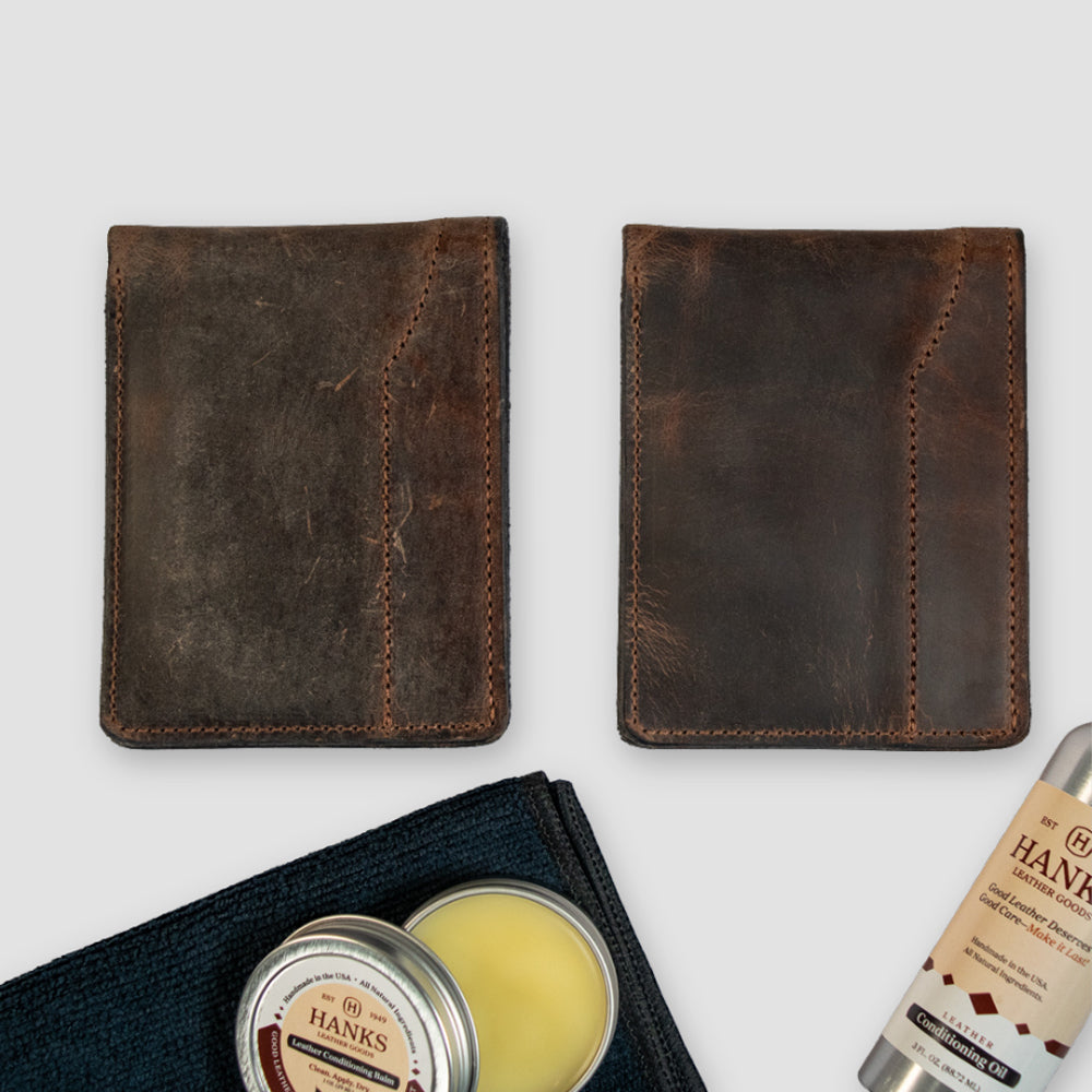 Two brown leather wallets, one more worn than the other, are shown side by side. Below them are Hanks Belts&#39; Leather Preserve Kit: a tin of conditioner, a black cloth, and cleaning solution—essentials for preserving leather goods.