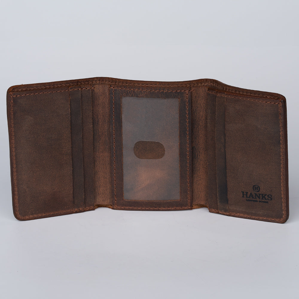The Hanks Belts Grainmark Line Trifold is an open brown full-grain leather wallet with multiple compartments, a center clear ID slot, and the &quot;HANKS&quot; logo at the bottom right, shown empty on a light background.