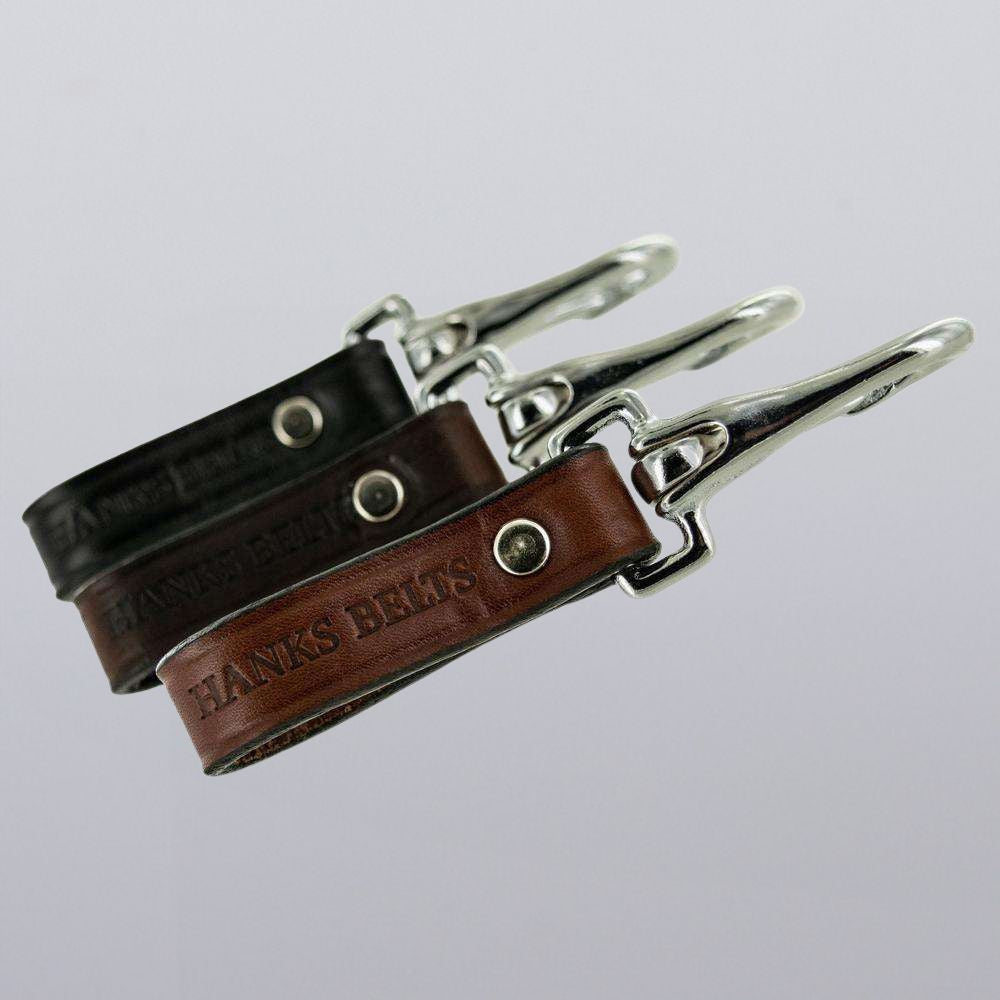 Two Hanks Belts Canyon Keychains in brown and black are shown against a plain background, each featuring rugged clips and &quot;HANKS BELTS&quot; embossed on the leather.