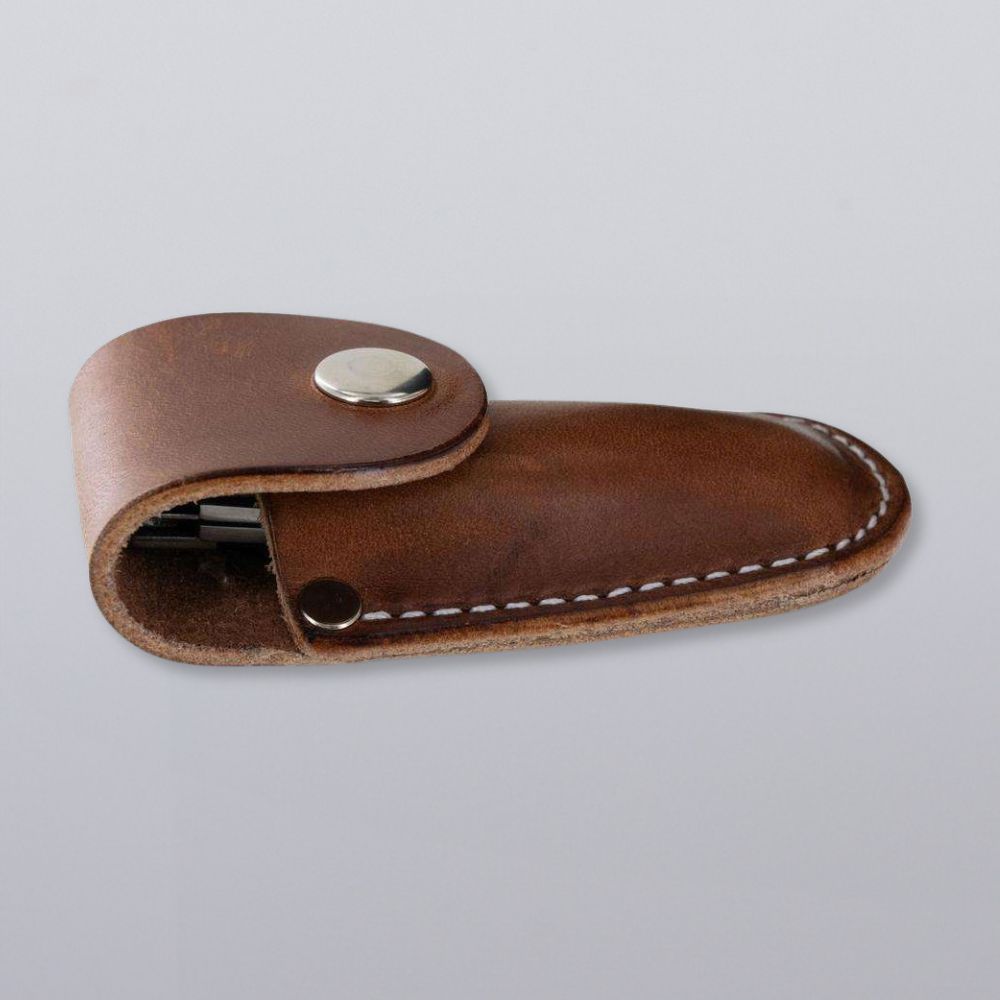 The Canyon Utility Sheath and Mag Case by Hanks Belts is a brown bridle leather sheath with white stitching and a metal snap, designed to hold a small tool or pocketknife. Shown on a plain gray background.