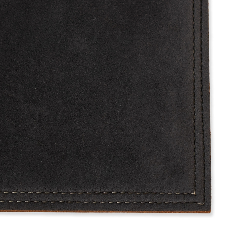Close-up of North American Bison leather from the Hanks Belts Desk &amp; Mouse Pad Set, showcasing visible stitching around the edges. The texture is soft and smooth, with neatly aligned stitching that highlights excellent craftsmanship. Handmade in the USA, this piece exudes quality and elegance for a premium desk and mouse pad experience.