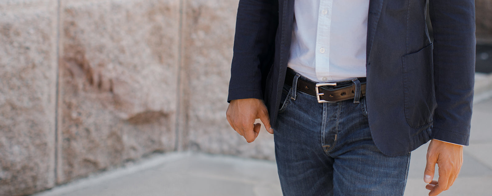 Male model waling outdoors wearing black esquire paired with jeans and white button up