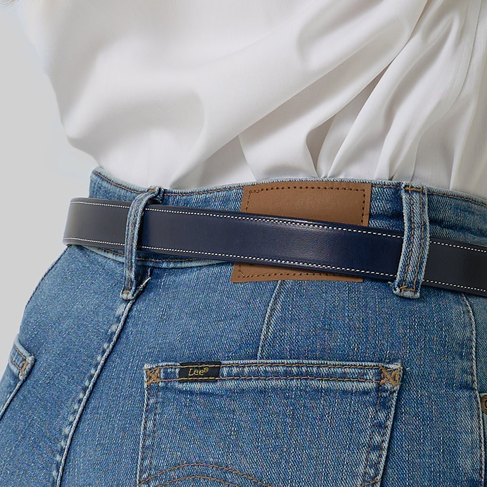 A person wears a white shirt tucked into high-waisted blue jeans with a brown leather patch and a limited-edition Hanks Belts &quot;Midnight Grace - 1&quot; navy belt; the &quot;Lee®&quot; label appears on the back pocket.