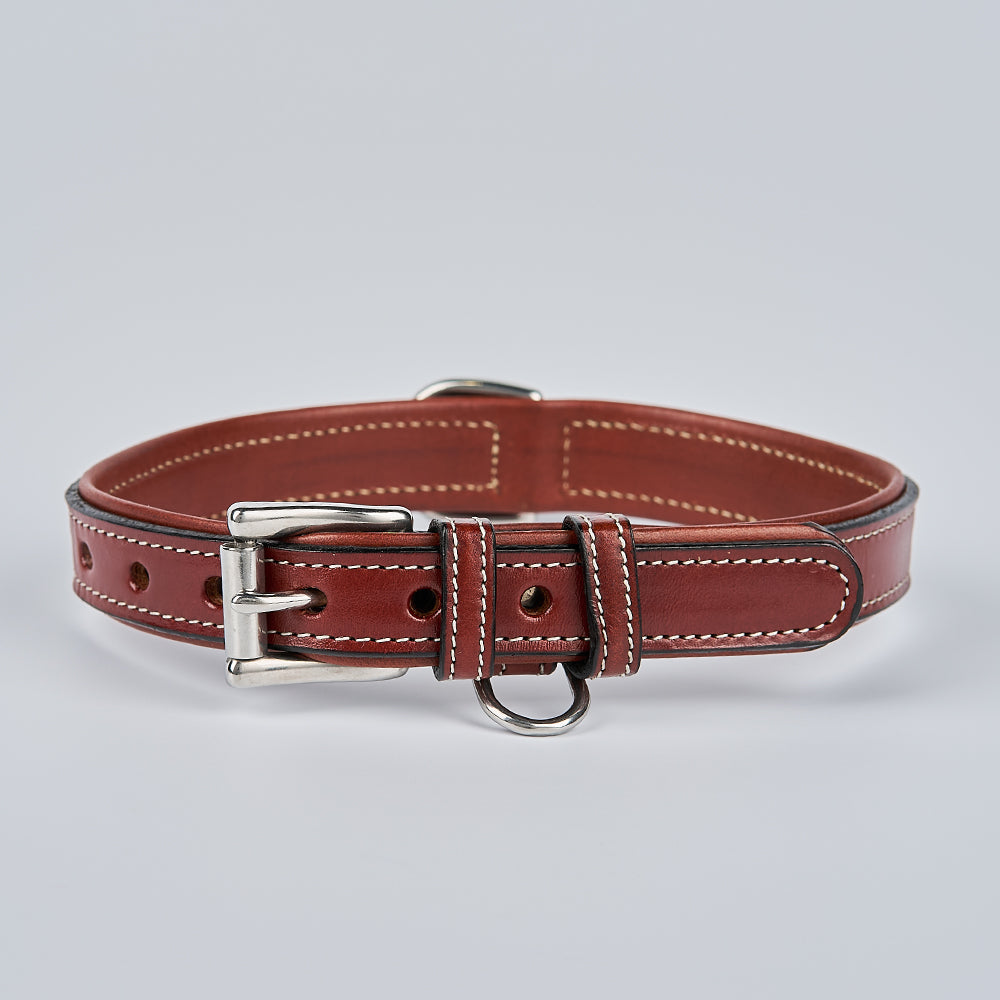 The Hanks Belts Rover Standard Collar is crafted from brown vegetable tanned leather with white stitching, featuring a silver buckle, adjustment holes, and a metal D-ring, shown on a plain light gray background.