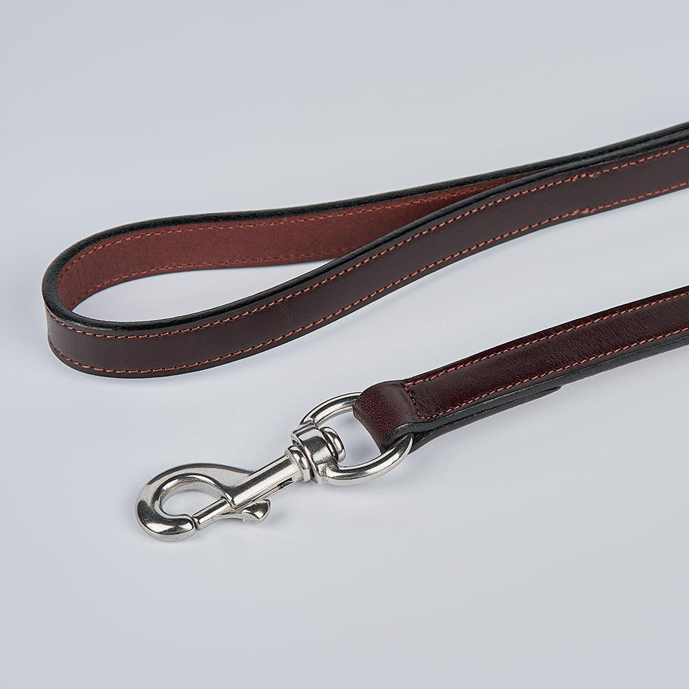 The Hanks Belts Old Reliable Leash, crafted from USA-made English bridle leather with visible stitching and a silver metal clasp, is coiled on a plain light gray background.