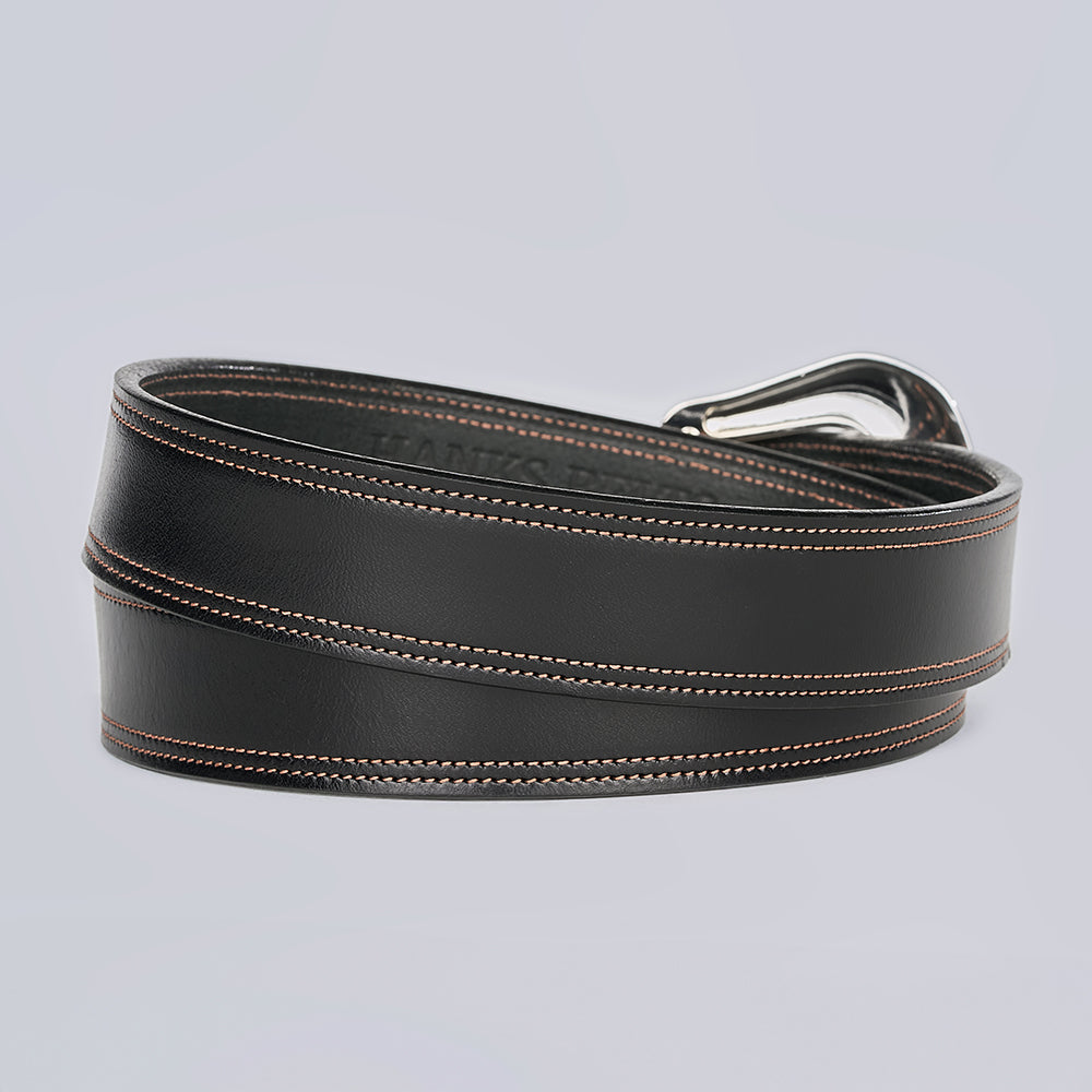 The Amarillo by Hanks Belts: a full-grain leather belt with brown stitching and a silver buckle, coiled and displayed on a light gray background.