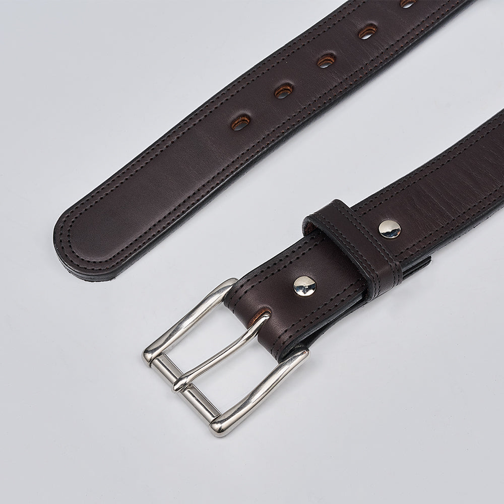A close-up of The Brute Double Layer belt by Hanks Belts, featuring dark brown USA Steerhide leather, a silver double-prong buckle, and multiple adjustment holes, displayed on a plain light background.