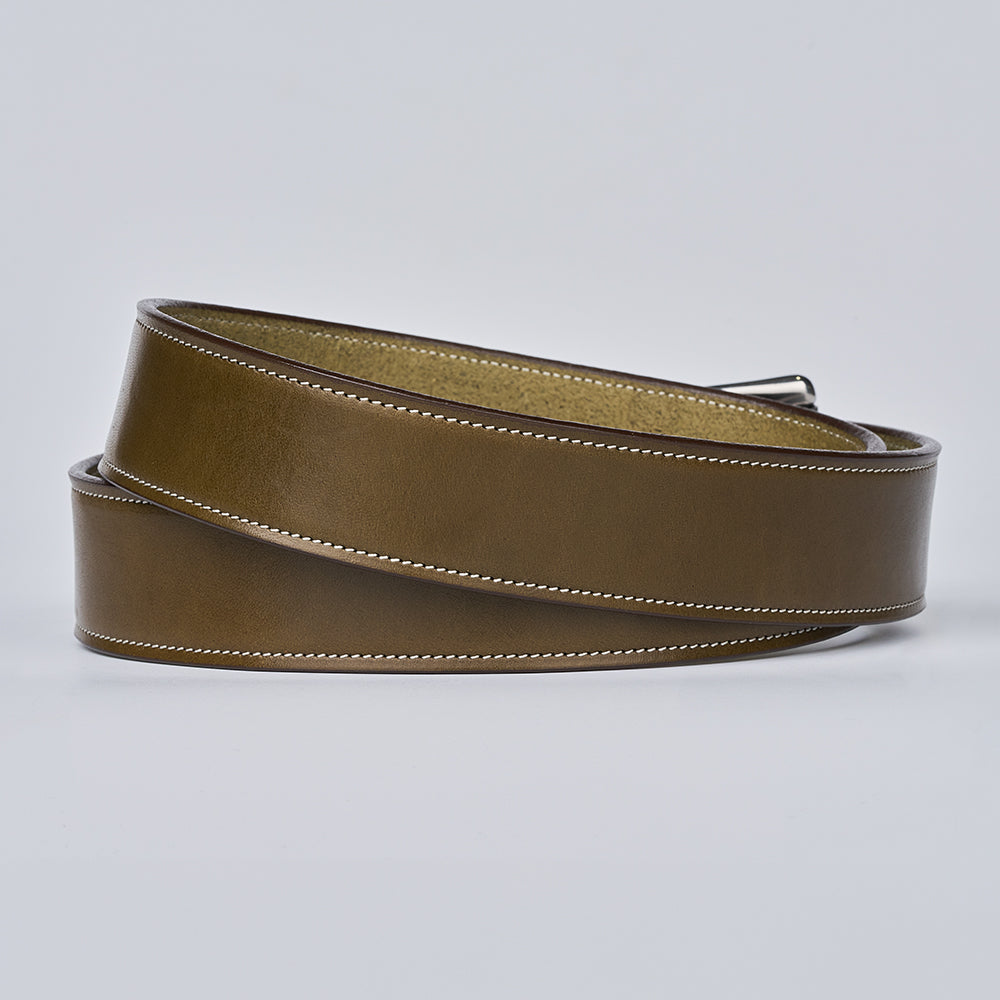 The Canyon by Hanks Belts, a handcrafted English bridle leather belt with white stitching, is coiled on a light gray background to highlight its smooth texture and polished finish.