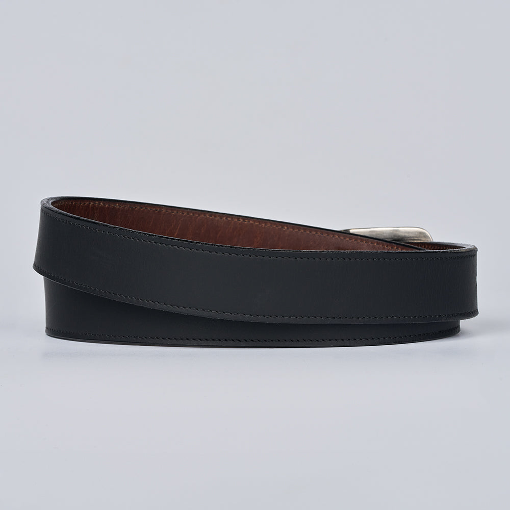The Dakota Bison by Hanks Belts: a coiled black bison leather belt with brown edges and a silver buckle, shown on a plain light gray background.