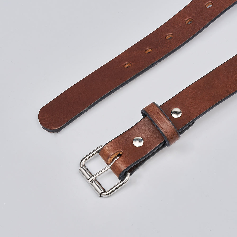 The Deputy by Hanks Belts is a brown leather gun belt with a silver buckle and metal rivets, shown on a light gray surface. Multiple adjustment holes make it perfect for concealed carry.