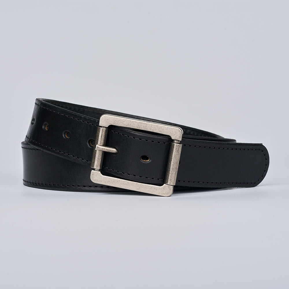 The Double Roller by Hanks Belts—a full-grain leather belt with a silver rectangular buckle—coiled neatly on a plain light gray background.