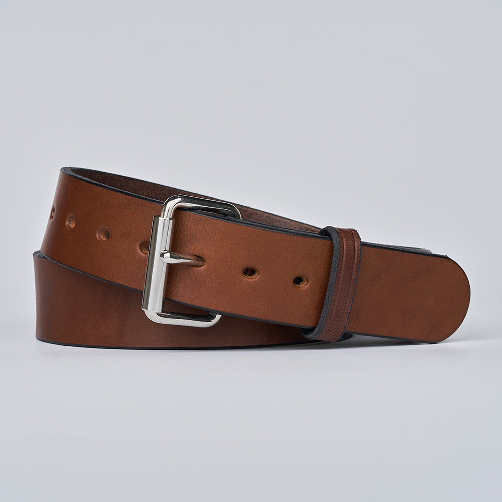 The Enforcer by Hanks Belts—a brown leather gun belt with a silver rectangular buckle—coiled neatly on a plain light gray background.