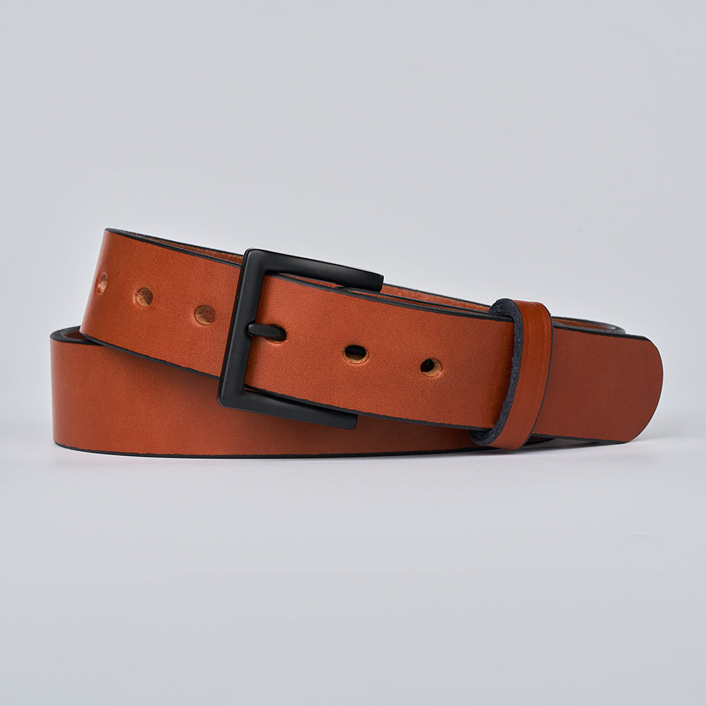 The Everyday by Hanks Belts is a durable men&#39;s oak leather belt with a matte black rectangular buckle, coiled on a light gray background.
