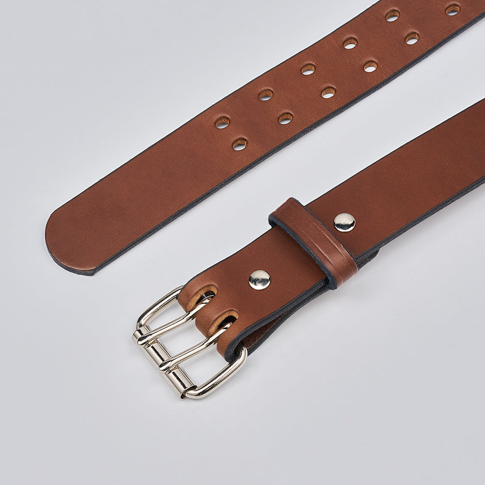 The Double Prong Everyday by Hanks Belts is a brown full-grain leather belt with a silver buckle and multiple round holes, shown laid flat on a light gray background.