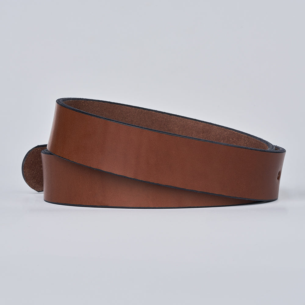 The Gunner by Hanks Belts is coiled on a light gray background, showing its smooth texture and dark edge—an ideal and reliable choice for everyday CCW carry.
