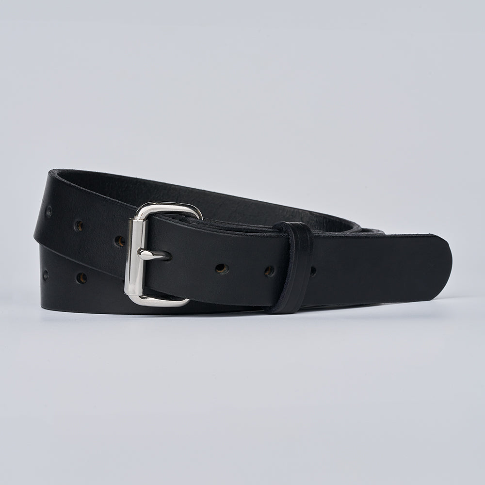 The Gunner Utility by Hanks Belts, a black leather belt with a silver buckle, is rolled up and displayed on a plain light gray background.