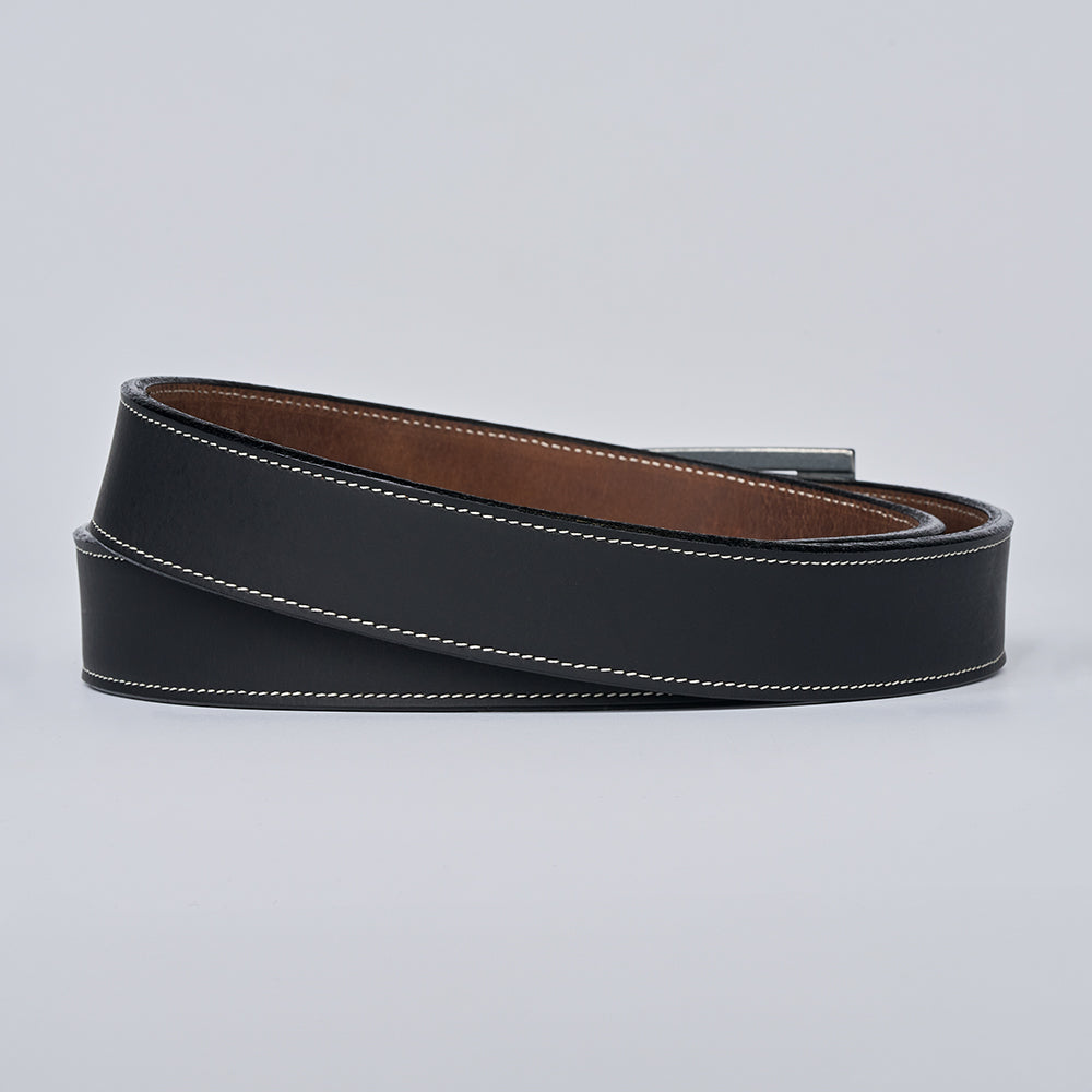 The Heritage Bison by Hanks Belts—a coiled black bison leather belt with white stitching and a brown inner lining, crafted in the USA—rests on a plain light gray background.
