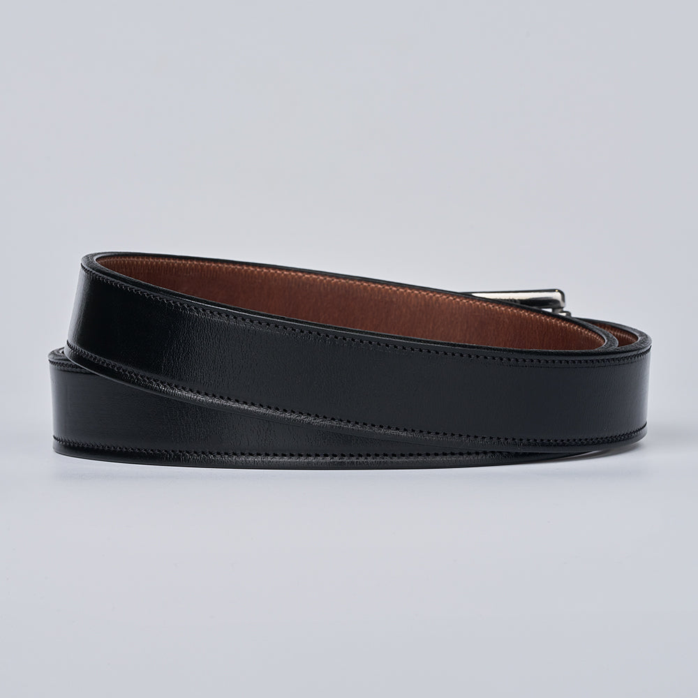 The Highland Lined by Hanks Belts: a premium black leather belt with brown inner lining and silver buckle, displayed coiled on a light gray background.