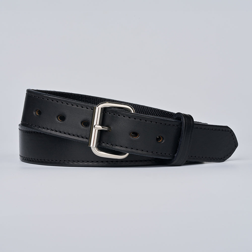The Kydex Reinforced by Hanks Belts, a black leather concealed carry belt with a silver metal buckle, is shown neatly rolled up against a plain light gray background.