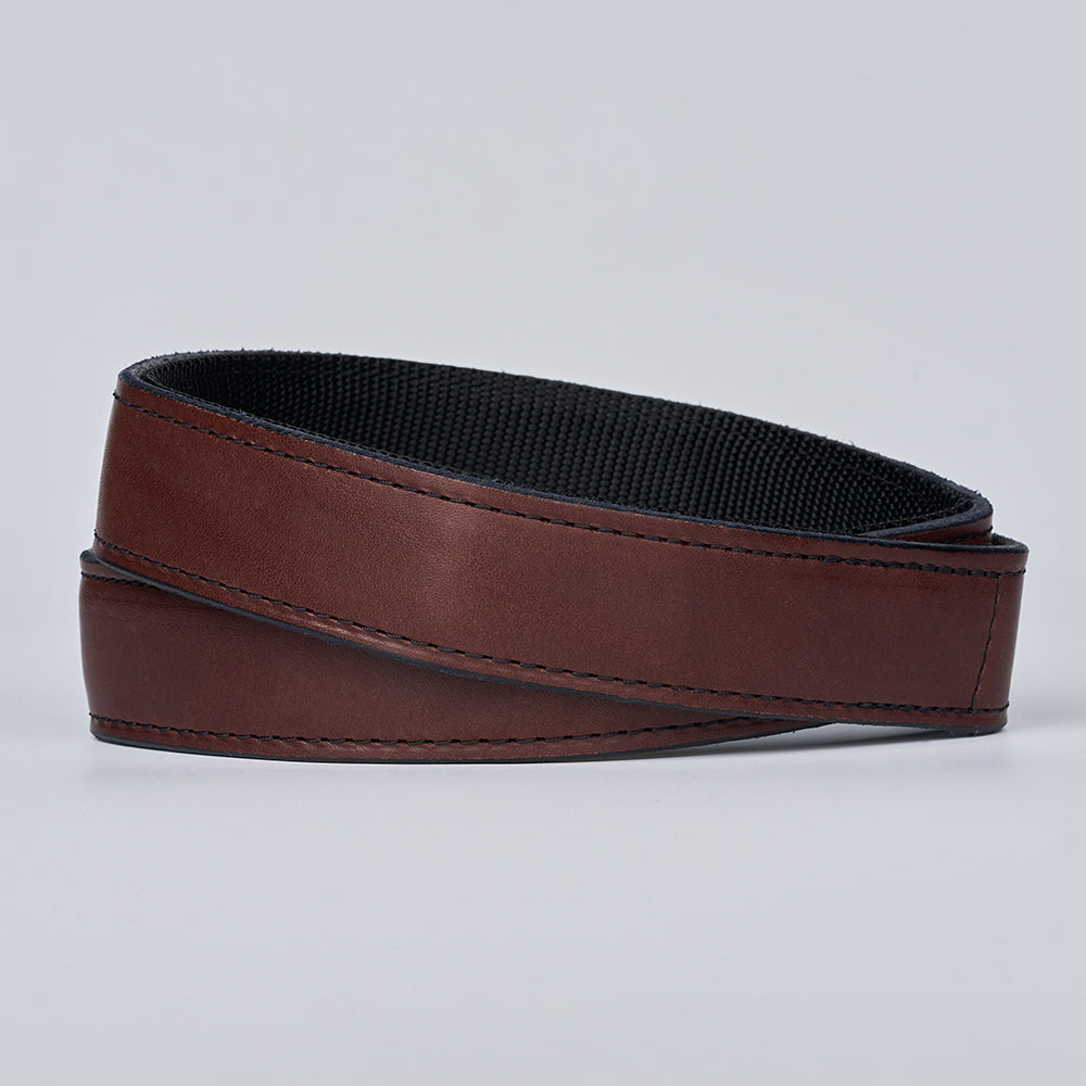 The Kydex Reinforced by Hanks Belts is a coiled brown reinforced gun belt with a black textured inner lining, shown against a plain light gray background.