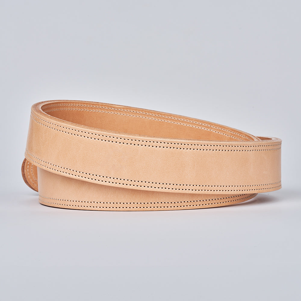 The Premier Double Layer by Hanks Belts is a coiled, light tan English bridle belt with detailed edge stitching, crafted from premium vegetable-tanned leather and displayed against a plain light gray background.