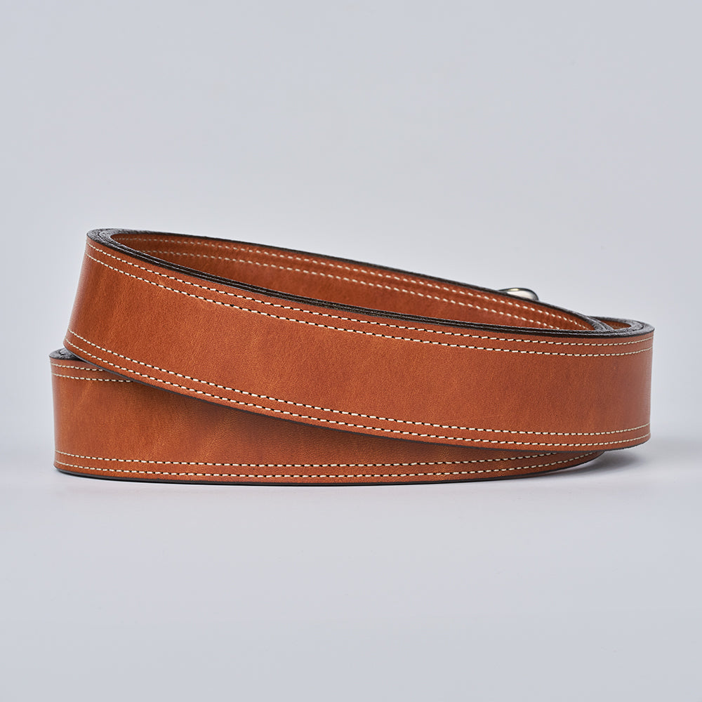 The Premier Double Layer by Hanks Belts is a coiled brown English bridle belt featuring white edge stitching, displayed on a plain light gray background.
