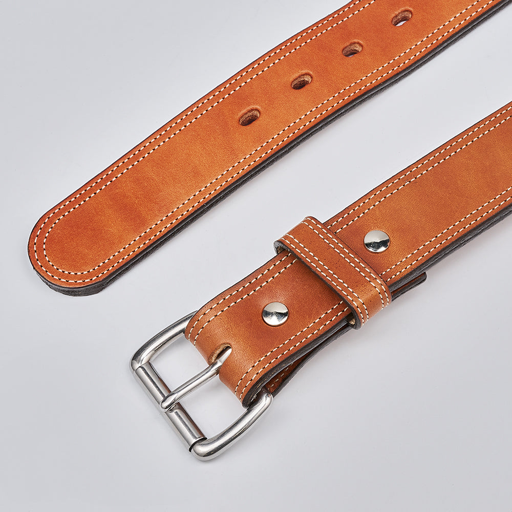 A close-up of The Premier Double Layer by Hanks Belts, an English bridle leather belt with white stitching, metal rivets, and a silver buckle, shown on a light gray background.