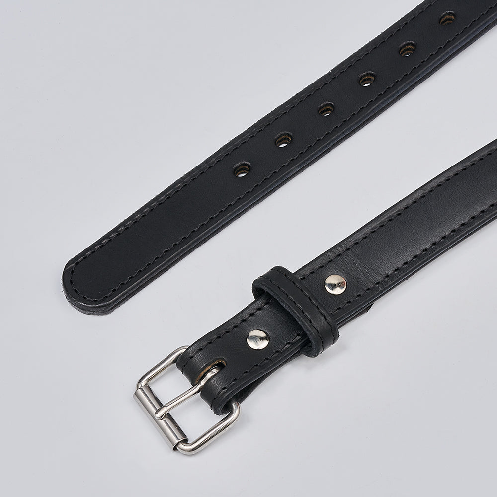 A close-up of Hanks Belts&#39; The Steel Core - 1.25&quot; black leather gun belt features a silver-tone buckle, metal rivets, and multiple adjustment holes, displayed on a plain light gray background.