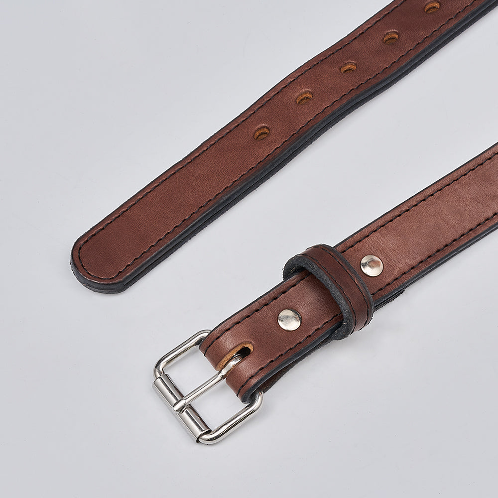 The Hanks Belts Steel Core - 1.25&quot; is a brown leather gun belt with a silver buckle and metal rivets, laid flat on a light surface. The strap features multiple holes for adjustable sizing.