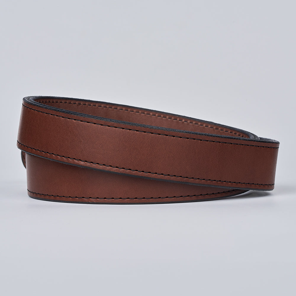 The Steel Core - 1.5&quot; by Hanks Belts is a coiled brown leather CCW gun belt with black edging and visible stitching, shown on a light gray background.