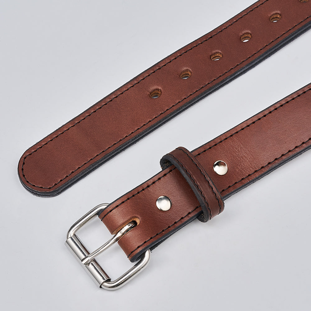 A close-up of Hanks Belts&#39; The Steel Core - 1.5&quot;, a brown leather CCW gun belt with a silver buckle and multiple holes, laid flat on a light gray surface.
