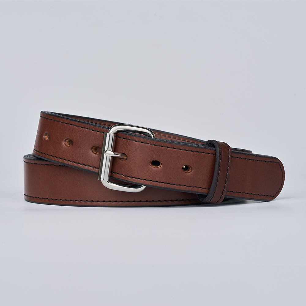 The Hanks Belts Steel Core 1.5&quot; brown leather CCW belt, featuring a silver metal buckle, dark edge stitching, and multiple adjustment holes, is coiled on a plain light gray background—designed for reliable concealed carry use.
