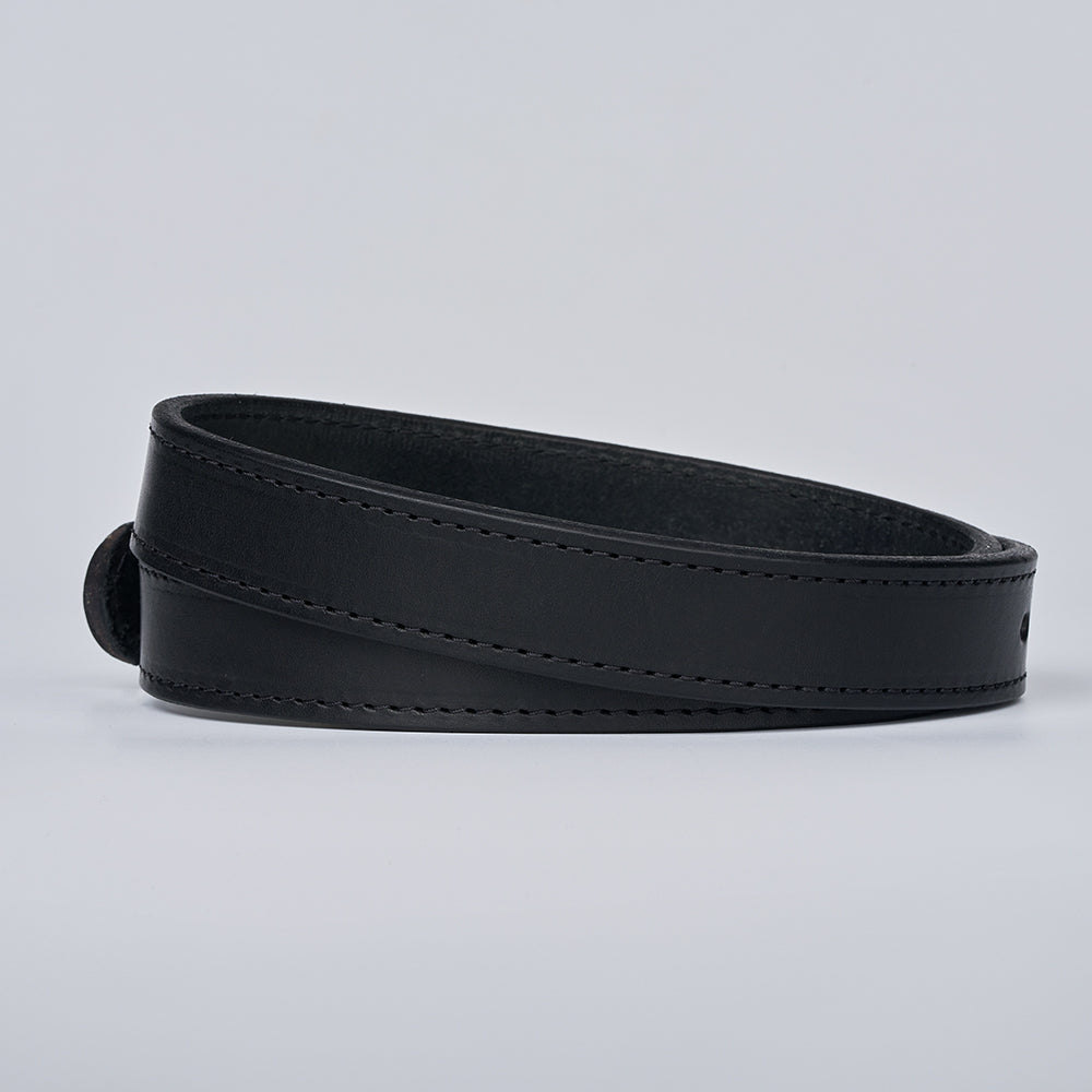 The Xtreme - 1.25&quot; by Hanks Belts is a black leather gun belt with visible stitching, neatly coiled in a circular shape on a plain light gray background.