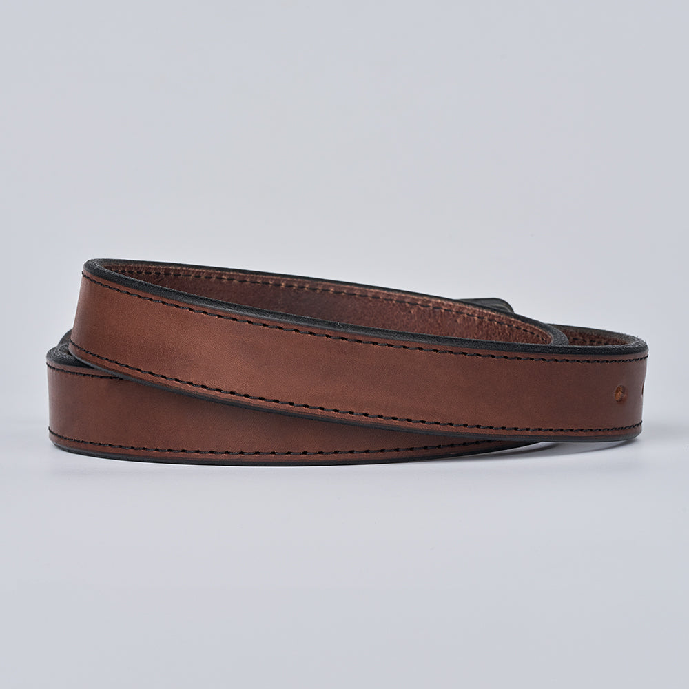 The Xtreme - 1.25&quot; by Hanks Belts is a coiled brown leather gun belt with black edges and visible stitching, shown on a plain light gray background.