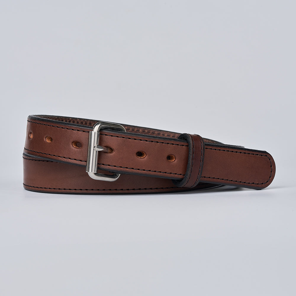 The Xtreme - 1.25&quot; gun belt by Hanks Belts in brown leather features a silver rectangular buckle and is shown neatly rolled on a plain light gray background.