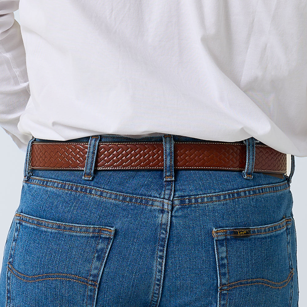 Seen from behind, a person in blue jeans and a white shirt wears The Classic Basket Weave belt by Hanks Belts around their waist.