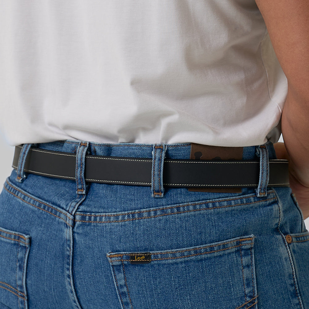 A person in blue jeans and a white t-shirt, shown from the back waist down, wears Hanks Belts&#39; The Heritage Bison rugged leather belt threaded through their belt loops.