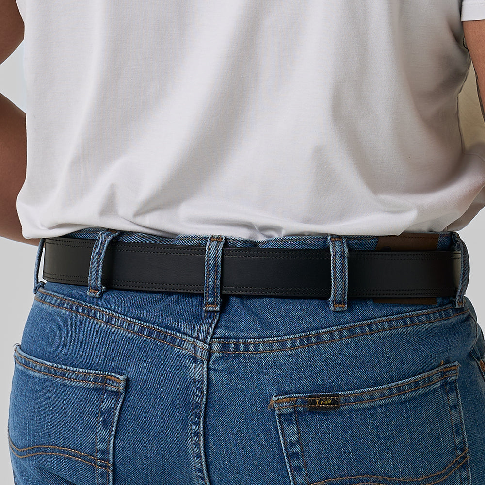 Person shown from the back wearing blue jeans with &quot;Tees&quot; waistband label and a white t-shirt. The jeans have two visible back pockets and a Hanks Belts The Old World Harness black full-grain leather belt, ideal for concealed carry.