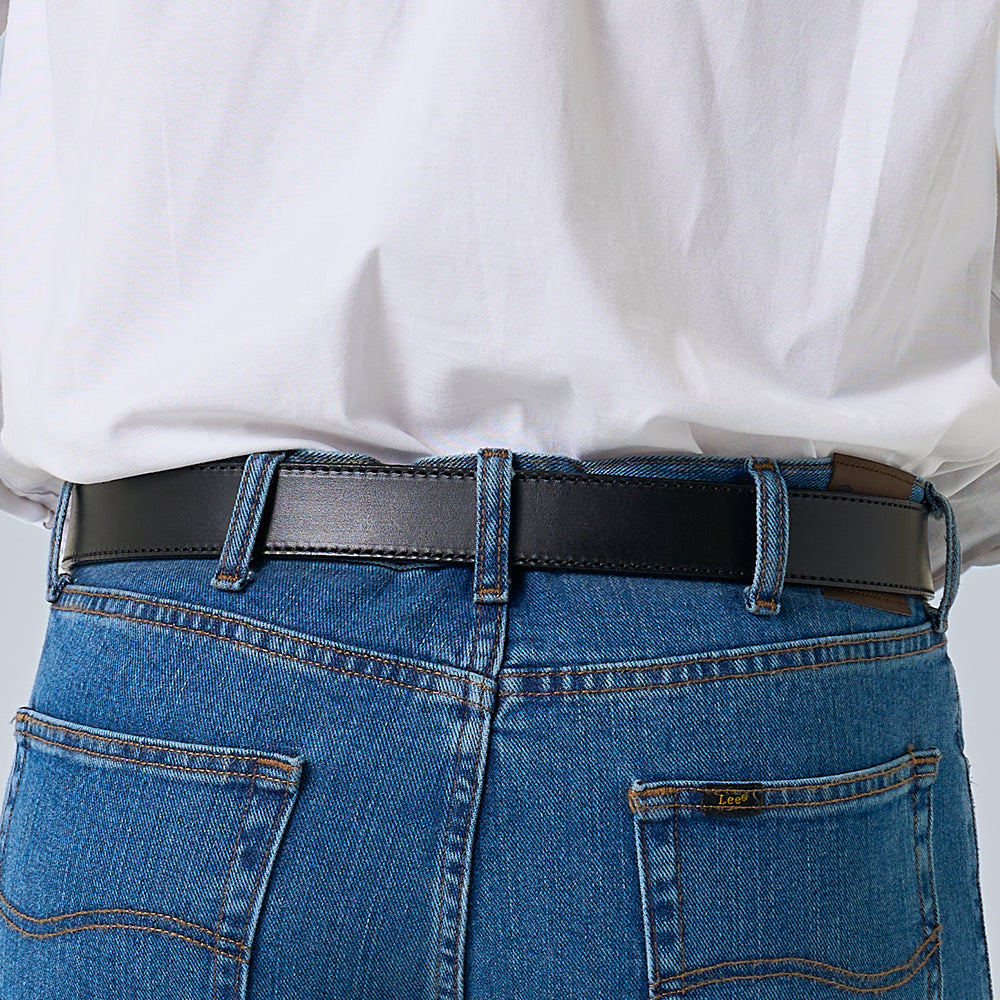 A person in blue jeans and a tucked-in white shirt is shown from the back, wearing The Ranger by Hanks Belts—a full grain leather belt with visible stitching threaded through the jeans’ belt loops.