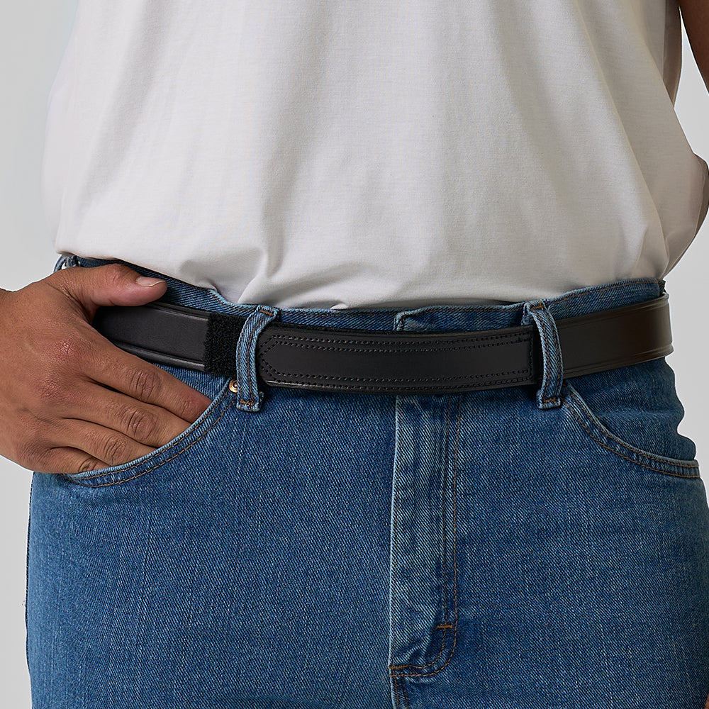 A person wearing blue jeans, a white shirt, and The Scratchless Mechanics full grain leather belt by Hanks Belts, with one hand on their hip and thumb hooked in the pocket.