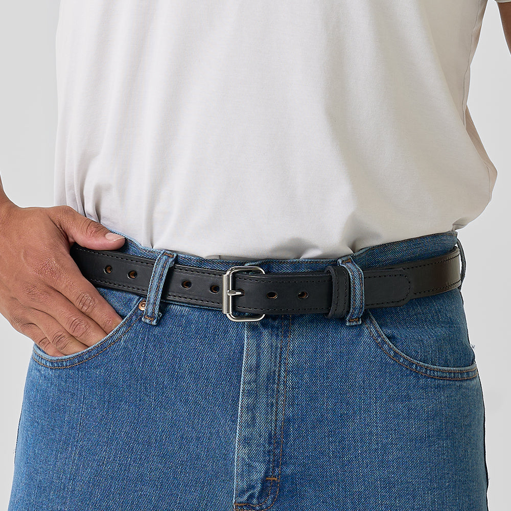 The Xtreme - 1.25" by Hanks Belts is a black leather gun belt with a silver buckle, coiled on a light gray background. It features multiple adjustment holes and visible edge stitching.