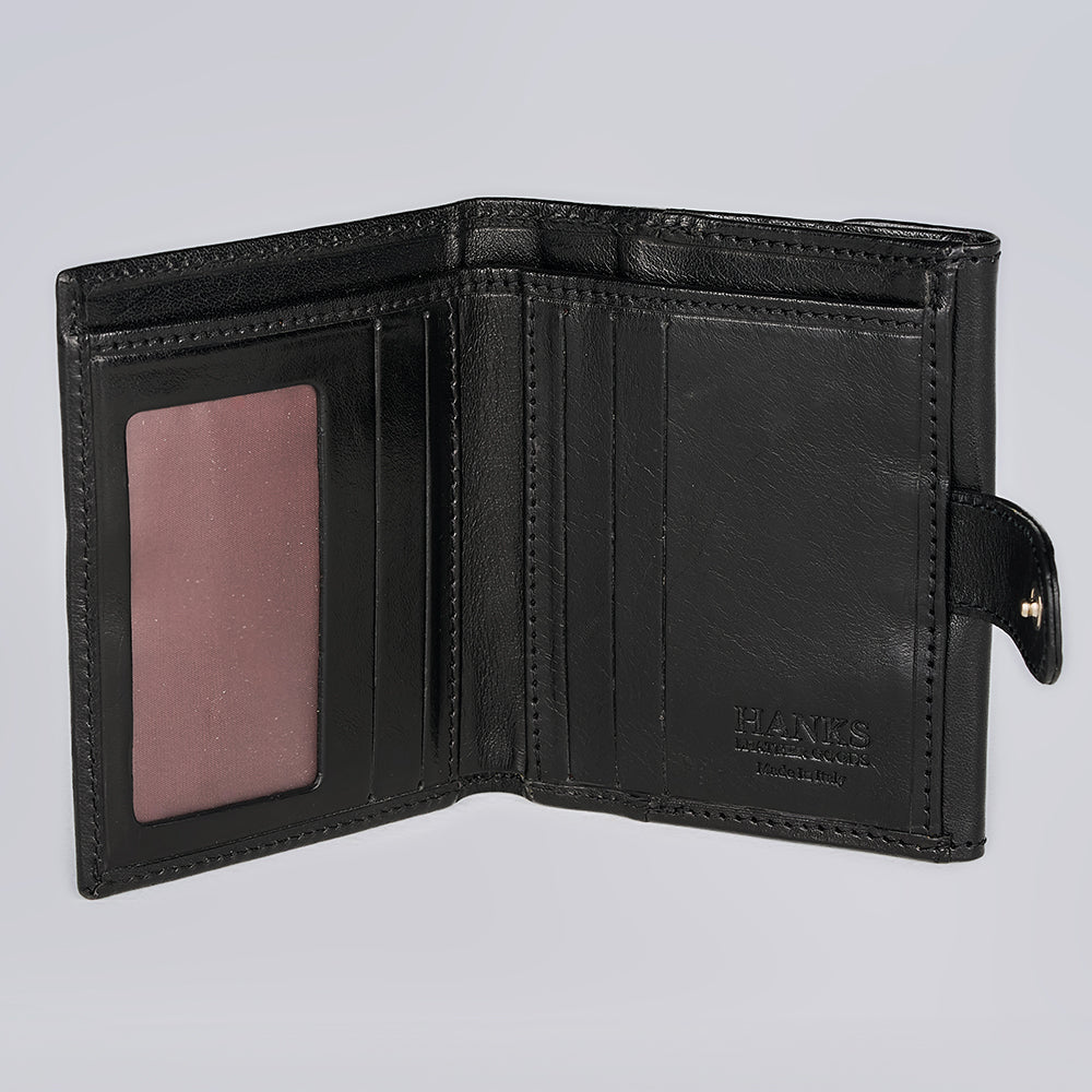 The Adelina Mini Bifold by Hanks Belts is a black Italian leather wallet, open to reveal multiple card slots, a clear ID window, and a small buttoned tab on the right. "Hanks Belts" is embossed inside.