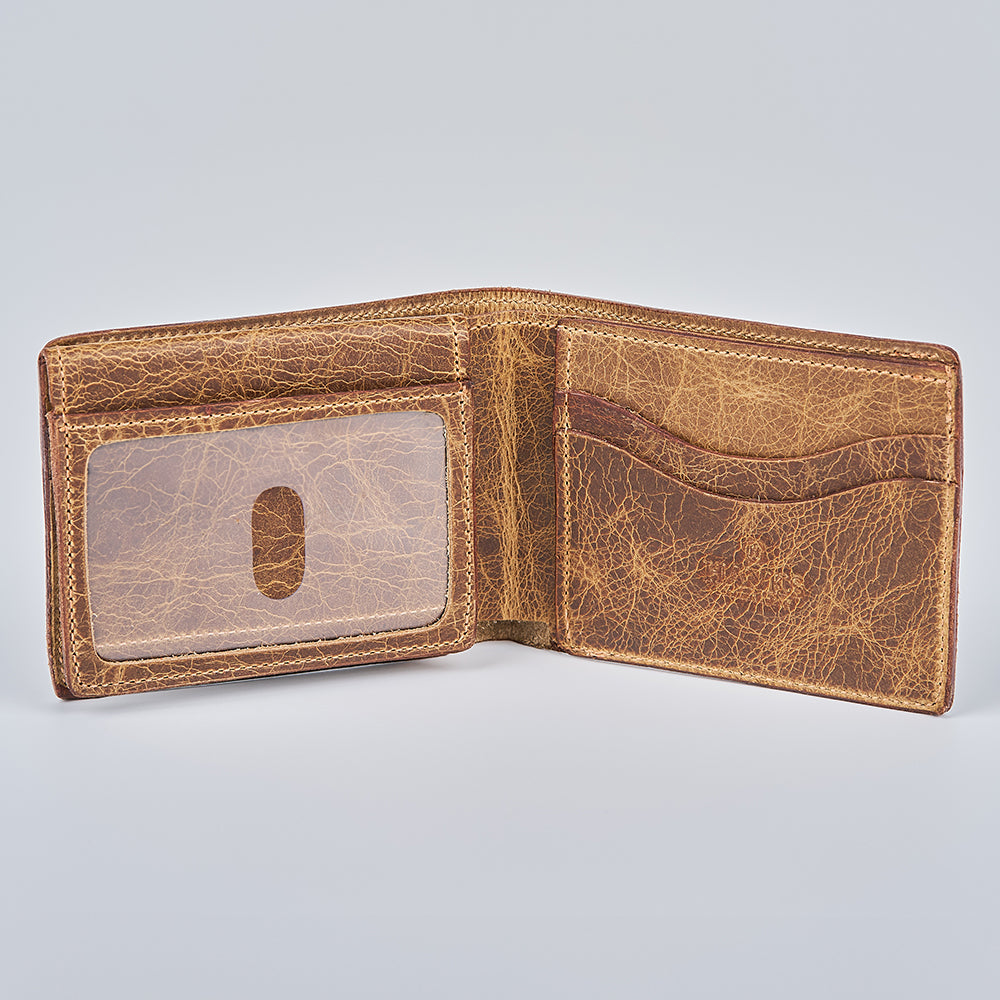 The Champlain Bison Bifold with ID Window by Hanks Belts is an open American-made brown Bison leather wallet, featuring an ID window on the left, multiple card slots on the right, and visible stitching, shown on a plain light gray background.